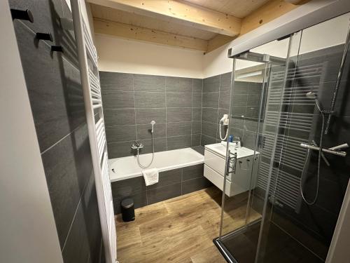 a bathroom with a shower and a tub and a sink at Chalet-Style Apartment Sonnleitn Nassfeld in Hermagor