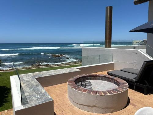 a fire pit with a view of the ocean at Jongensfontein Beachside Villa in Jongensfontein