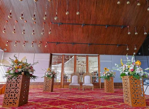 a banquet hall with chairs and flowers on a rug at The Oasis Mussoorie - A Member of Radisson Individuals in Mussoorie