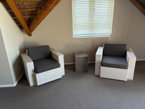 two chairs and a table in a room at Jongensfontein Beachside Villa in Jongensfontein