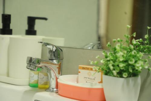 a bathroom sink with a faucet and a plant at Ivy Bliss Studio with Common Pool, B 14, Karjat in Karjat