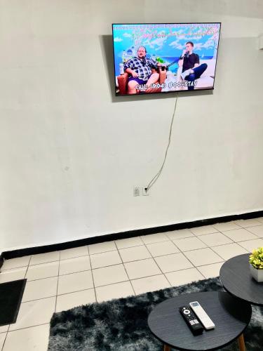 a flat screen tv hanging on a wall with two tables at Departamento Completo En Centro de Monterrey in Monterrey