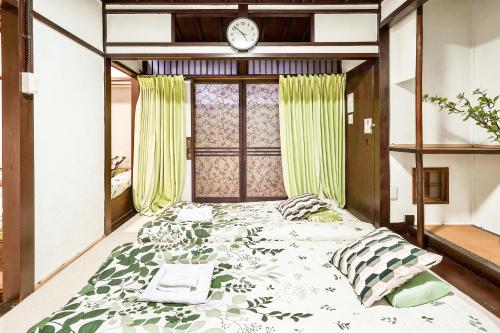 a bedroom with a large bed with a clock on the wall at Shalom 鶴橋 市中心地铁口徒步10秒可到民宿 地铁6分钟直达难波 大阪3条地铁交汇处 30分钟直达奈良 in Osaka