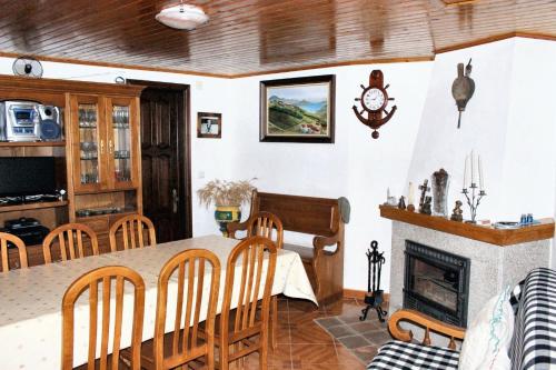 a dining room with a table and a fireplace at Charming House in Paredes do Rio with Mountain View in Paredes do Rio