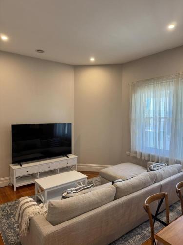 a living room with a couch and a flat screen tv at 1920's Local Heritage Character home 'Rangatira' 3 bedroom, 2 living room family home in Mount Gambier