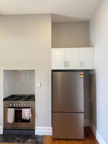 a kitchen with a stainless steel refrigerator and an oven at 1920's Local Heritage Character home 'Rangatira' 3 bedroom, 2 living room family home in Mount Gambier