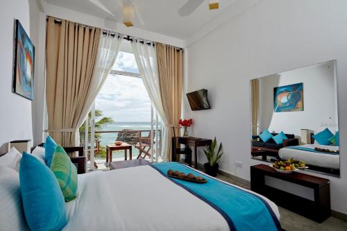 a bedroom with a bed with a view of the ocean at Garton's Cape in Ahangama