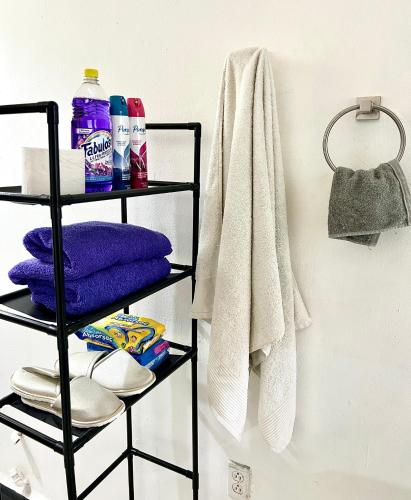 a black towel rack with towels and towels at Departamento Completo En Centro de Monterrey in Monterrey
