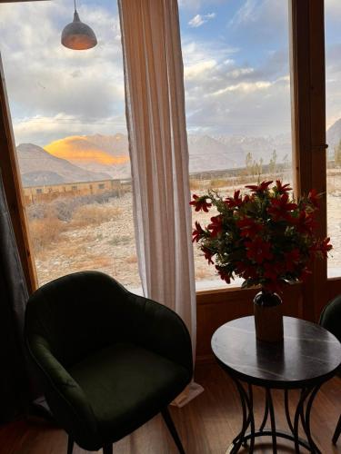 a room with a chair and a table and a window at Yeti Resort Hunder in Hundar