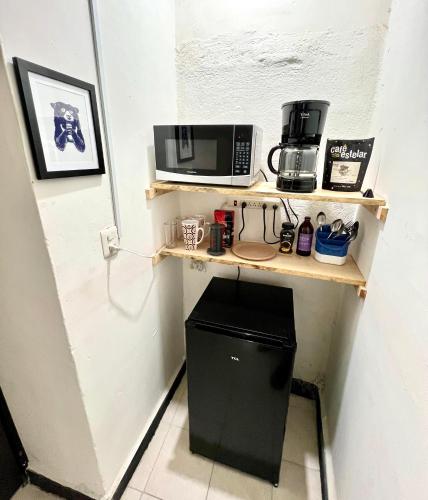 a kitchen with a shelf with a microwave and a trash can at Departamento Completo En Centro de Monterrey in Monterrey