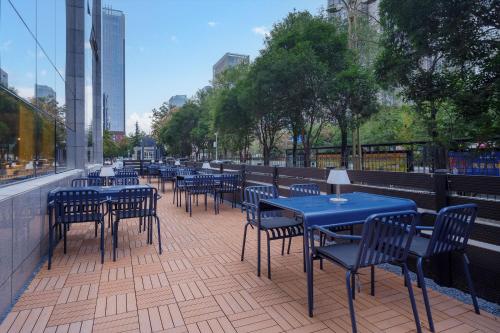 a row of blue tables and chairs on a patio at Atour Light Hotel Xi'an Jingkai North Railyway Station in Xi'an