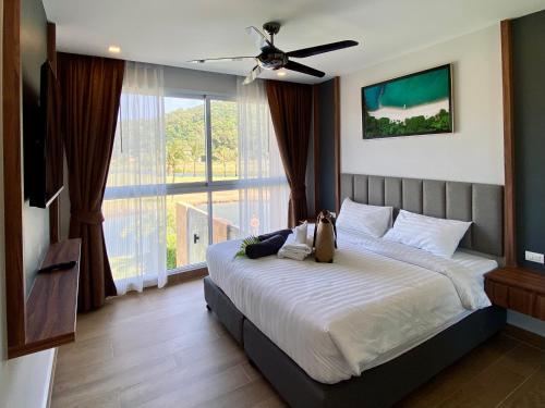 a bedroom with a large bed and a large window at Utalay Koh Chang Villas in Ko Chang
