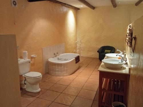 a bathroom with a tub and a toilet and a sink at The Retreat Country Lodge in Romelcoh