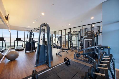 a gym with treadmills and machines in a building at Harper Kupang by ASTON in Kupang
