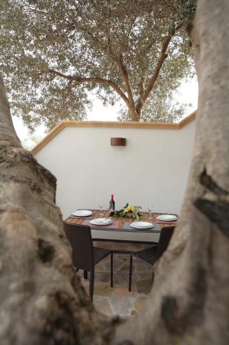 a table and chairs sitting under a tree at Bono Vacanze Villa San Marco Luxury Holidays Homes in Sciacca
