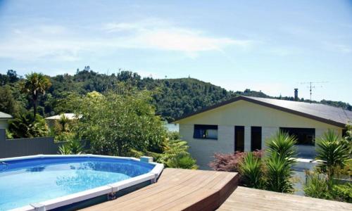 un cortile con piscina e una casa di Abel Tasman Kaiteriteri B & B a Kaiteriteri