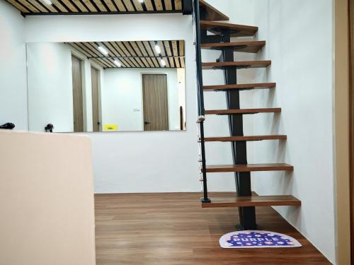 a wooden spiral staircase in a room with a mirror at T&C Boxhill Gated 5 Min To Kuching Airport 12Pax in Kuching