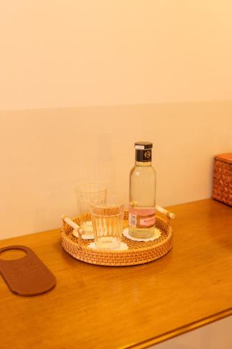 a bottle of alcohol and two glasses on a table at Hotel du Temps Madrid in Madrid