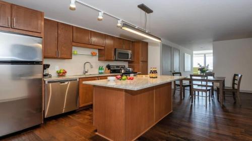 a kitchen with stainless steel appliances and wooden cabinets at 16th and 18th FL Bold CozySuites with pool gym in Dallas