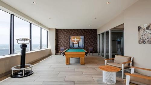 a pool table in a room with windows at 16th and 18th FL Bold CozySuites with pool gym in Dallas