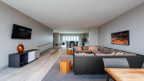 a living room with a couch and a tv at 16th and 18th FL Bold CozySuites with pool gym in Dallas
