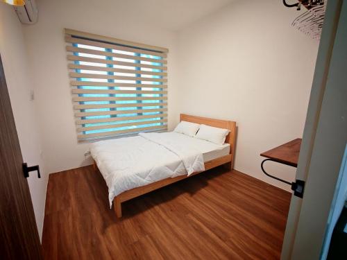 a small bedroom with a bed and a window at T&C Boxhill Gated 5 Min To Kuching Airport 12Pax in Kuching