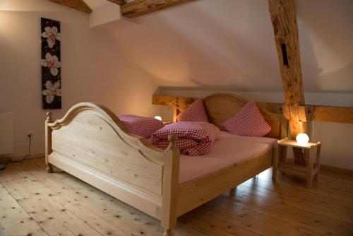 ein Schlafzimmer mit einem Holzbett mit Kissen darauf in der Unterkunft Hirschen B&B in Maienfeld