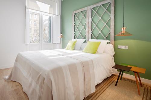 Un dormitorio con una gran cama blanca y una ventana en Simone by FeelFree Rentals, en San Sebastián
