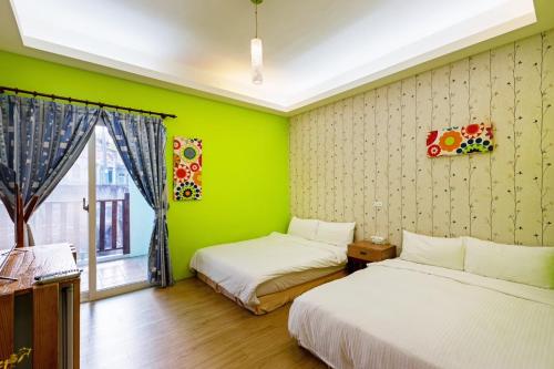 two beds in a room with green walls at 17 Happiness in Xiaoliuqiu