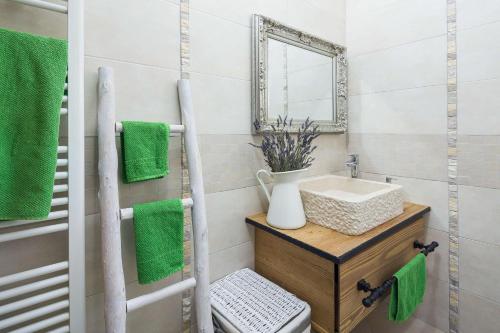 a bathroom with a sink and a mirror and green towels at Villa Stonegate Estate - Bonus, dvije vile jedna cijena! in Opatija