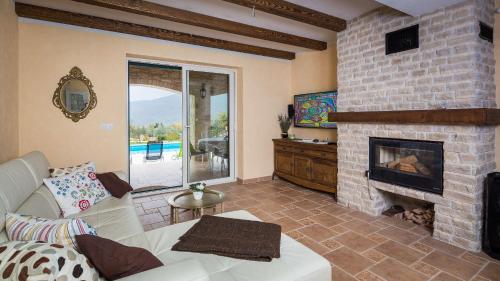 a living room with a fireplace and a white couch at Villa Stonegate Estate - Bonus, dvije vile jedna cijena! in Opatija