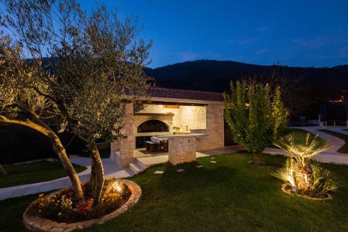 a backyard with a pizza oven in a brick house at Villa Stonegate Estate - Bonus, dvije vile jedna cijena! in Opatija