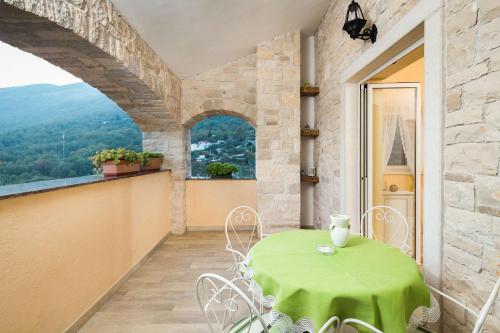 a green table and chairs on a balcony at Villa Stonegate Estate - Bonus, dvije vile jedna cijena! in Opatija