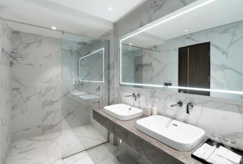 a bathroom with two sinks and a mirror at Clarks Inn Dehradun in Dehradun