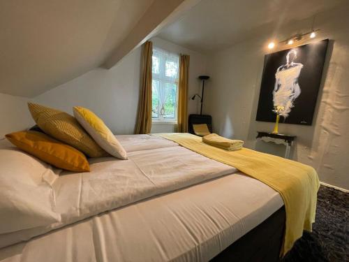 a bedroom with a large white bed with yellow pillows at BnB Stavanger at Ap2 Nice and Cozy Central 3 Rooms in Stavanger