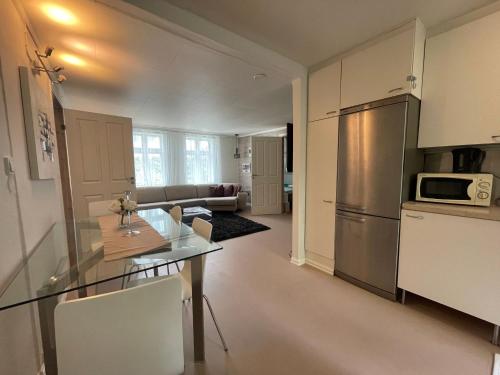 a kitchen and living room with a table and refrigerator at BnB Stavanger at Ap2 Nice and Cozy Central 3 Rooms in Stavanger
