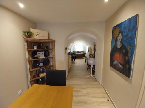 a hallway with a table and a painting on the wall at Garden Cottage Zebegény in Zebegény