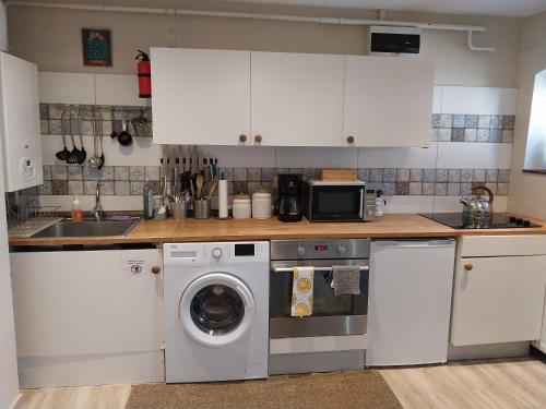 una cucina con lavatrice e microonde di Garden Cottage Zebegény a Zebegény