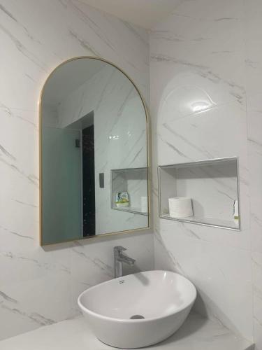 a white bathroom with a sink and a mirror at Sariaya Staycation-Pool, Jacuzzi, PS5 and WiFi in Sariaya