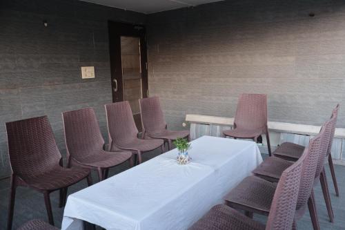 a table with chairs and a vase of flowers on it at Hotel Kabir in Ahmedabad