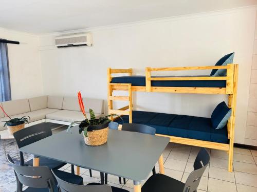 a living room with a table and a bunk bed at Mzingazi Waterfront Accommodation, On The Bay Waterfront Villa's in Richards Bay