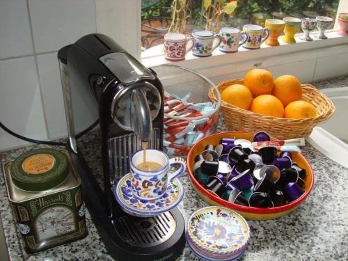 a coffee maker on a counter next to a basket of oranges at Boutiquehotel Sycamore - Protected City View - 950m from Central Station in Eindhoven