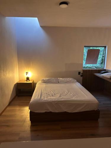 a bedroom with a bed and a lamp on a table at Casa Tonalli in Jocotepec