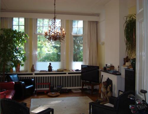 a living room with a radiator and two windows at Boutiquehotel Sycamore - Protected City View - 950m from Central Station in Eindhoven