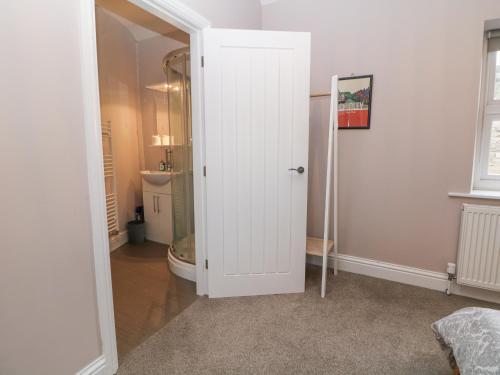 a white door in a room with a bathroom at Homestead in Chapel en le Frith