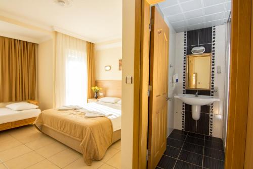 a hotel room with a bed and a sink at Hotel Karbel Sun in Oludeniz
