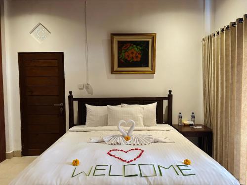 a bedroom with a bed with a welcome sign on it at Puri Jumpungan Villas in Sidemen