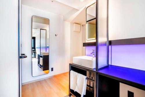 a bathroom with a sink and a mirror at YOTEL Tokyo Ginza in Tokyo
