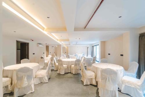 a room filled with white tables and white chairs at Vilmaris Luxe Hotel, Calangute in Calangute