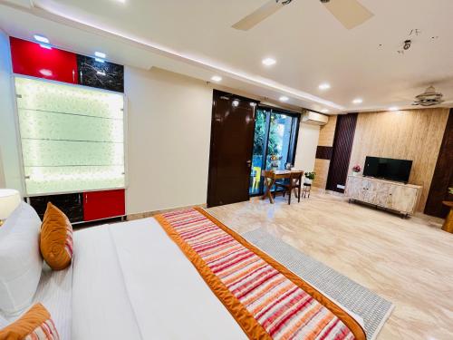 a living room with a white couch and a large screen at South Haven Residency - South Extension South Delhi in New Delhi
